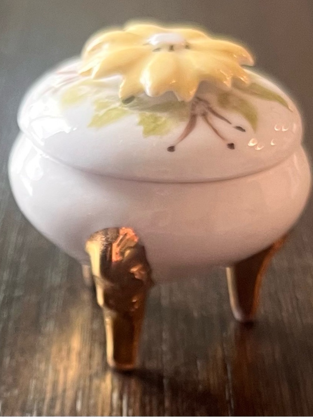 Vintage small porcelain footed trinket box with gold-toned legs and a floral lid